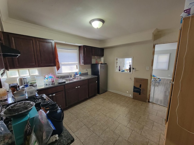 kitchen with sink, range hood, stainless steel fridge, dark brown cabinets, and white gas range oven