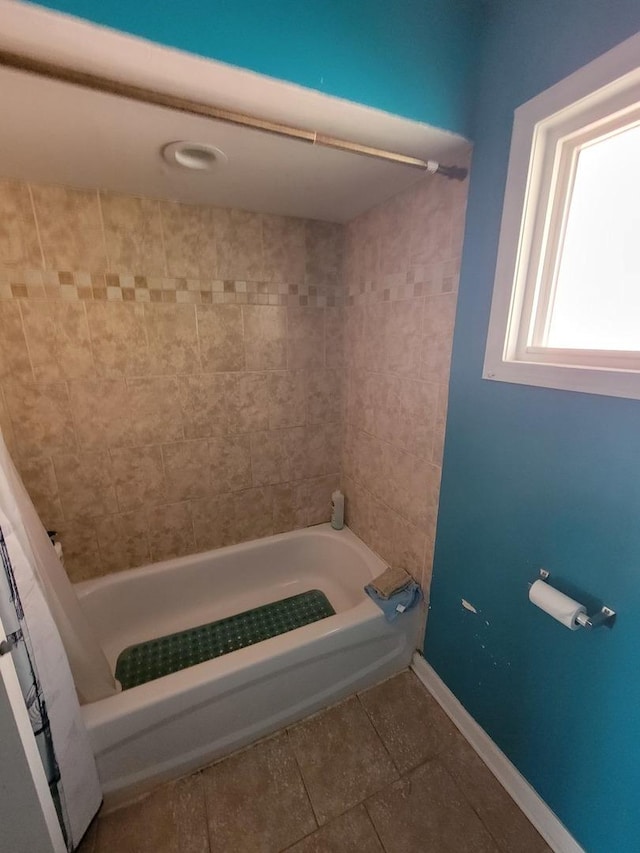 bathroom featuring tile patterned flooring and tiled shower / bath