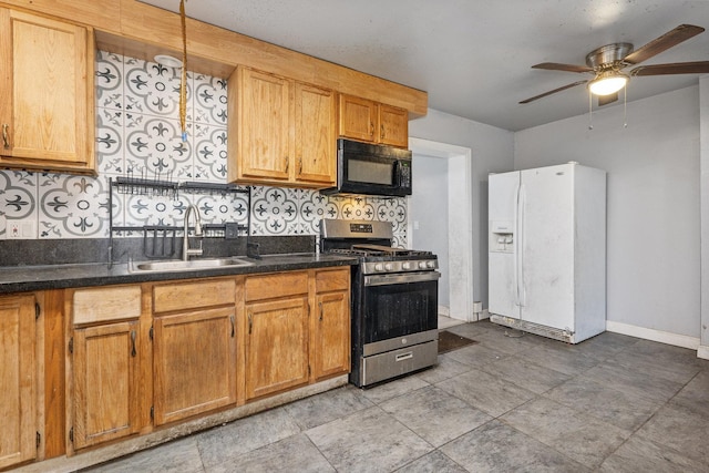 kitchen with stainless steel gas range, white refrigerator with ice dispenser, decorative backsplash, sink, and ceiling fan