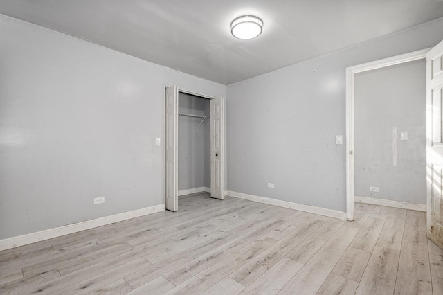 unfurnished bedroom featuring light hardwood / wood-style flooring and a closet