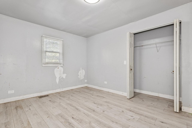 unfurnished bedroom with light hardwood / wood-style floors and a closet