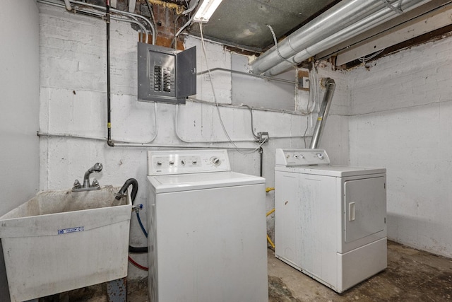 laundry area featuring sink, electric panel, and washing machine and clothes dryer