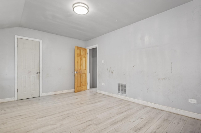 empty room featuring light hardwood / wood-style floors and lofted ceiling