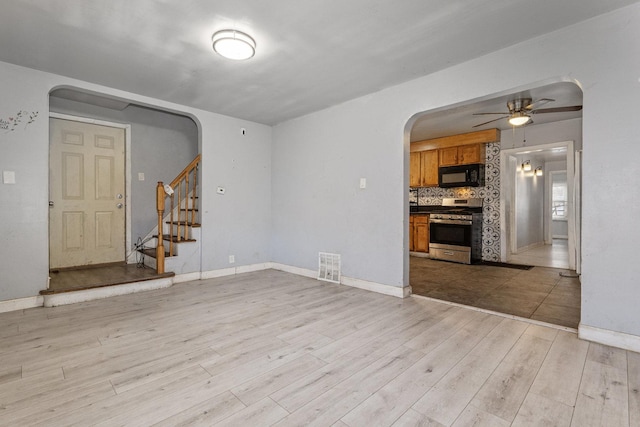 unfurnished living room with light wood-type flooring and ceiling fan