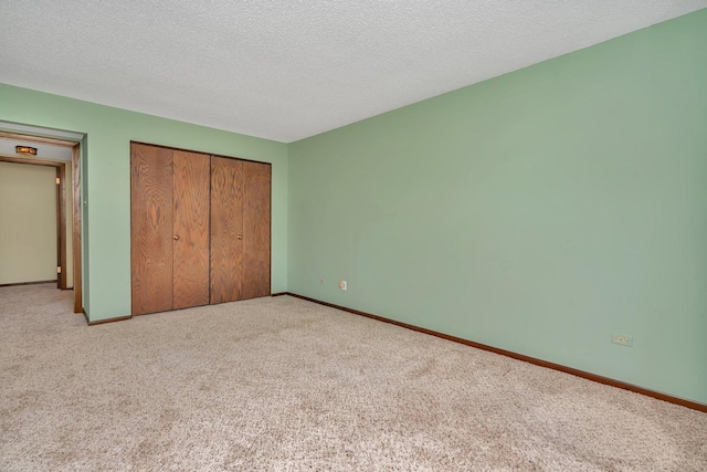 unfurnished bedroom with light carpet, a closet, and a textured ceiling