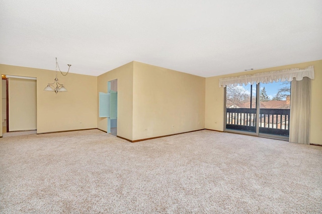 carpeted empty room with a notable chandelier