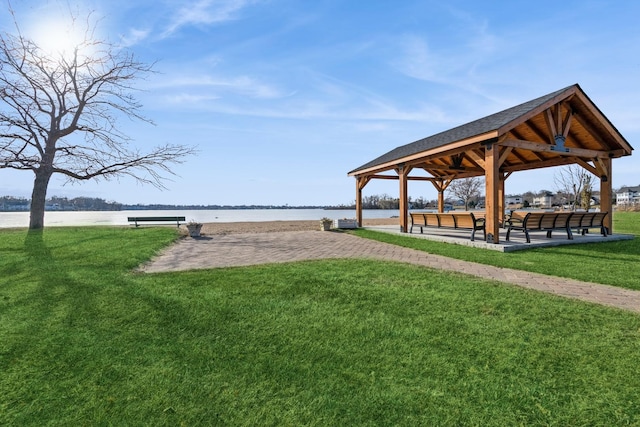 view of property's community with a gazebo, a water view, and a lawn