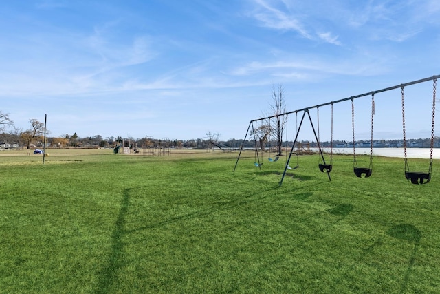 exterior space with a playground, a lawn, and a water view