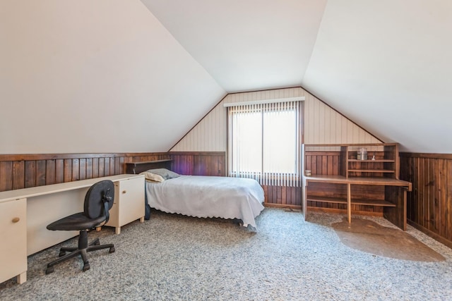 bedroom featuring carpet, lofted ceiling, and wood walls