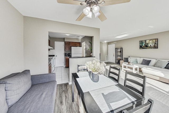 dining area with ceiling fan and light wood-type flooring