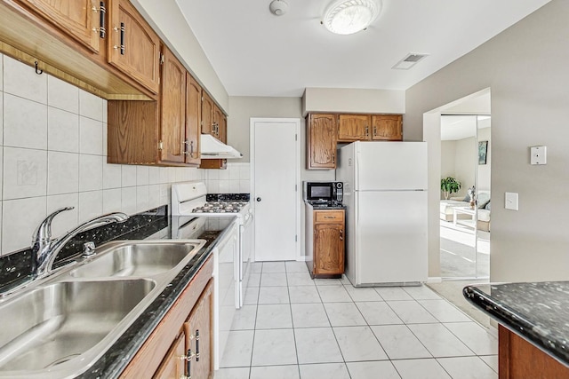 kitchen featuring light tile patterned floors, white appliances, tasteful backsplash, and sink