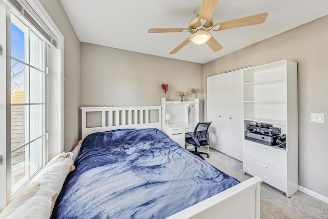 carpeted bedroom featuring ceiling fan and a closet