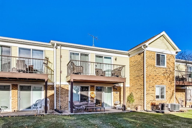 back of house featuring central AC, a balcony, and a patio