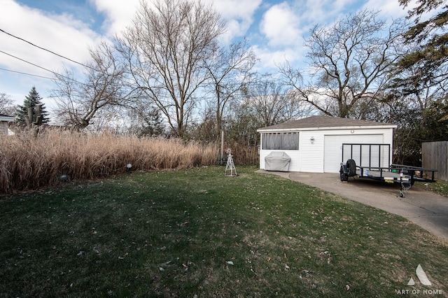 view of yard with a garage and an outbuilding