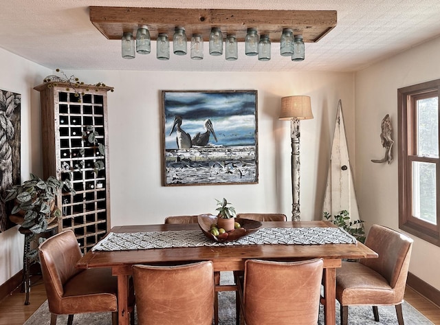 dining space with wood-type flooring and a textured ceiling