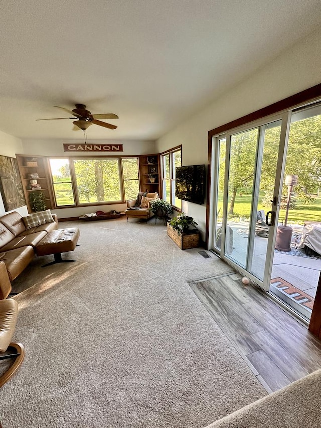 unfurnished living room featuring carpet flooring, ceiling fan, and a textured ceiling