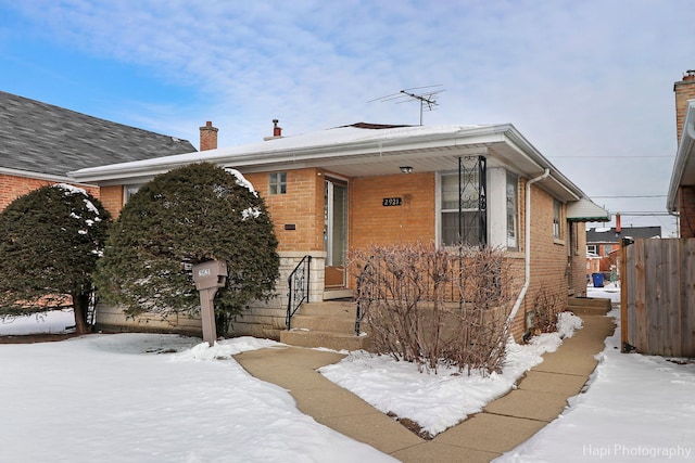 bungalow-style house with fence and brick siding