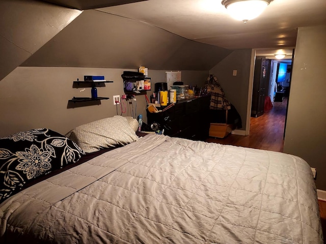 bedroom with wood-type flooring and vaulted ceiling