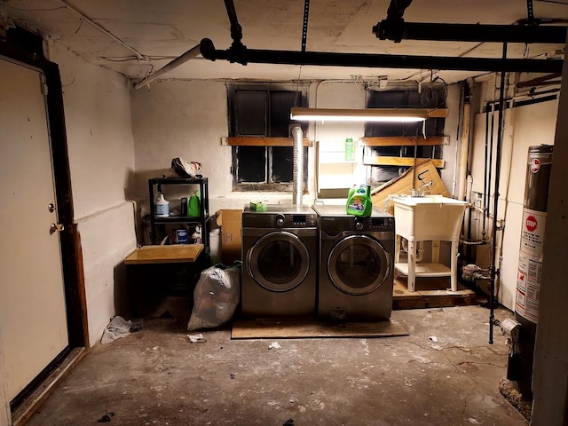 basement with water heater, washer and clothes dryer, and sink