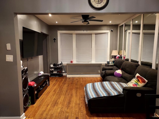 living room with ceiling fan, light wood-type flooring, and radiator