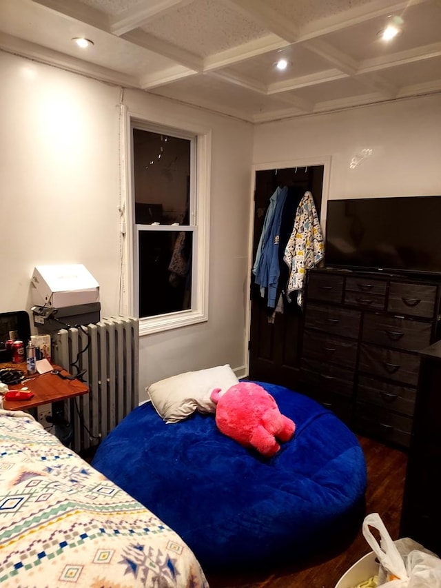 bedroom featuring beamed ceiling, radiator heating unit, dark wood-type flooring, and coffered ceiling