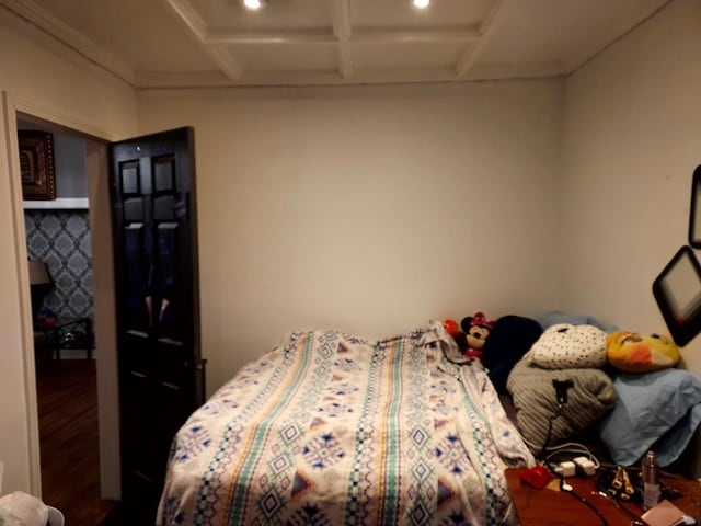 bedroom with coffered ceiling and hardwood / wood-style flooring