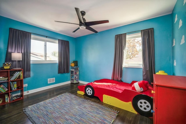 bedroom with multiple windows, ceiling fan, and dark wood-type flooring