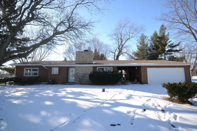 ranch-style home featuring a chimney and an attached garage