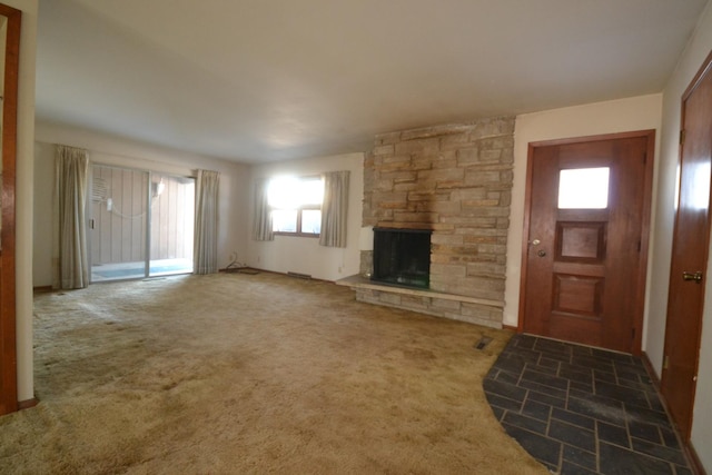 unfurnished living room featuring a fireplace and dark colored carpet