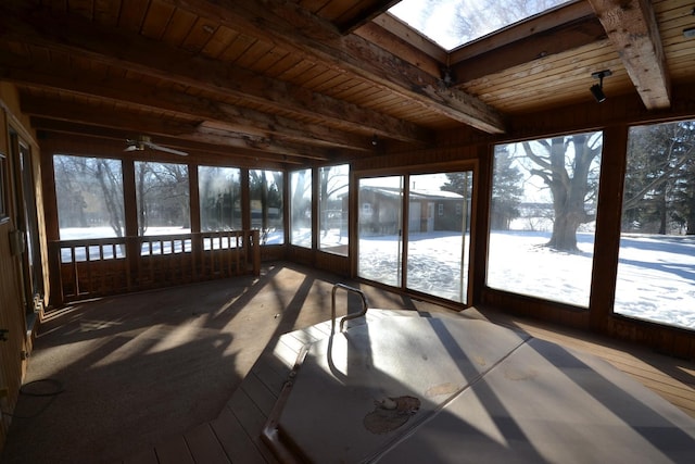 unfurnished sunroom with wooden ceiling, a skylight, and beamed ceiling