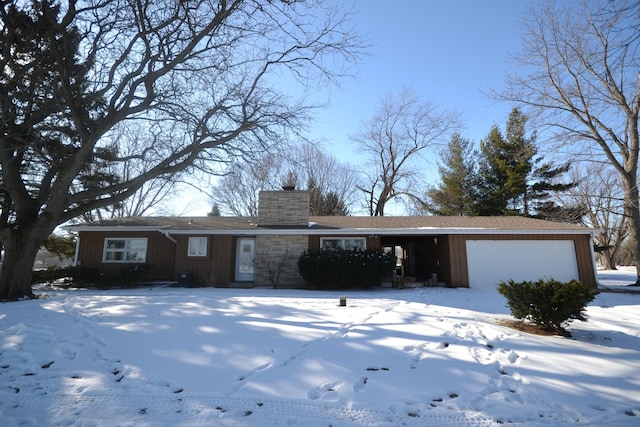 ranch-style house with a chimney and an attached garage