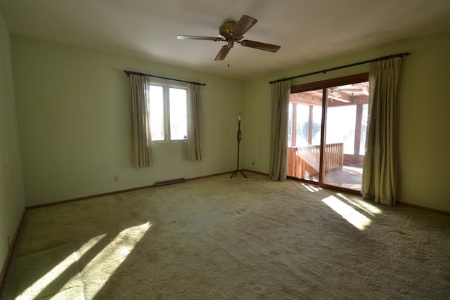 spare room with light carpet, visible vents, baseboards, and a ceiling fan