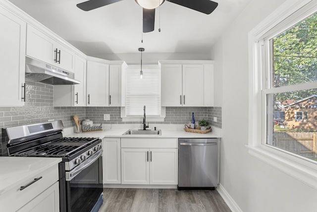 kitchen featuring white cabinets, sink, decorative backsplash, appliances with stainless steel finishes, and light hardwood / wood-style floors