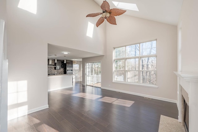 unfurnished living room with ceiling fan, high vaulted ceiling, and dark hardwood / wood-style floors