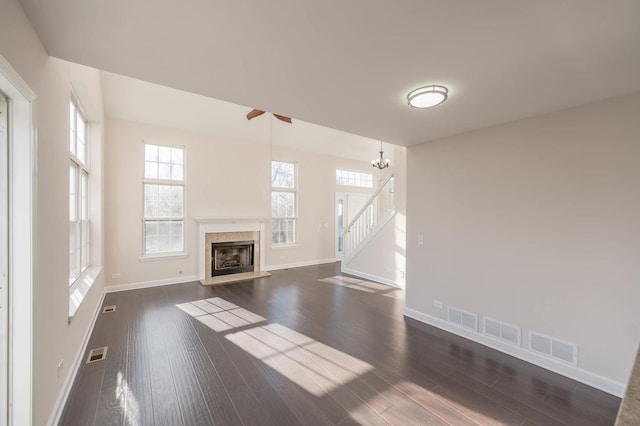 unfurnished living room with dark wood-type flooring and an inviting chandelier