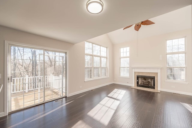 unfurnished living room with ceiling fan, dark hardwood / wood-style flooring, a wealth of natural light, and vaulted ceiling