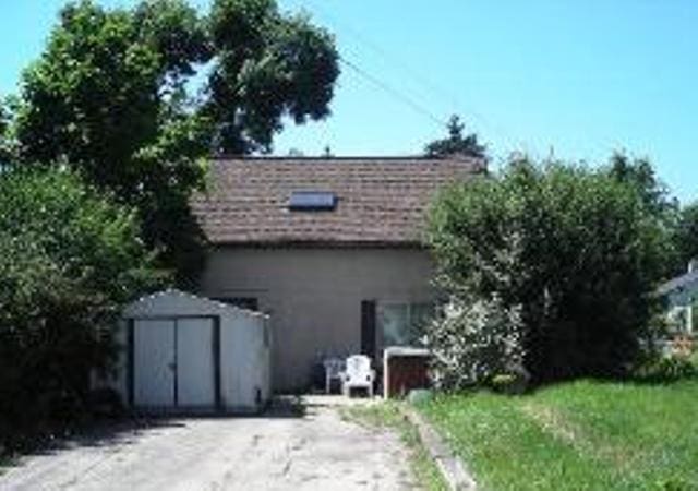 rear view of house featuring a storage shed