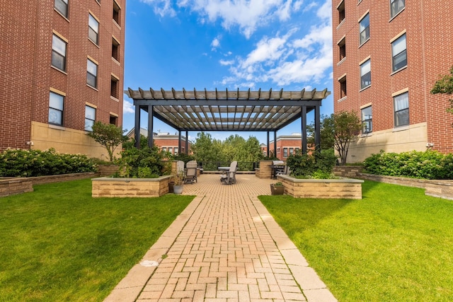 view of community featuring a lawn, a pergola, and a patio