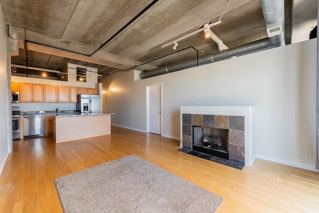 unfurnished living room with a fireplace and light wood-type flooring