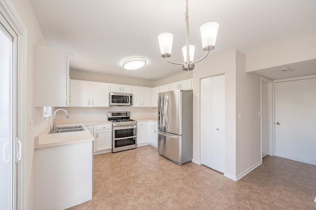 kitchen featuring sink, stainless steel appliances, a chandelier, decorative light fixtures, and white cabinets