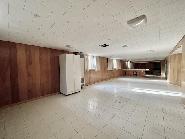 unfurnished living room featuring wood walls