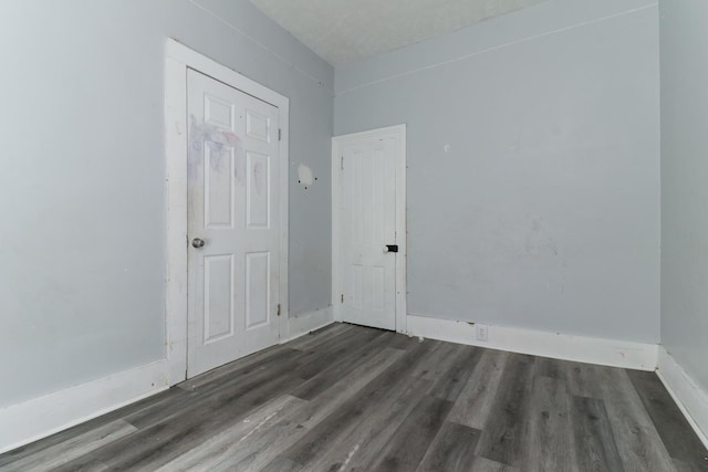 unfurnished room with dark hardwood / wood-style flooring and a textured ceiling