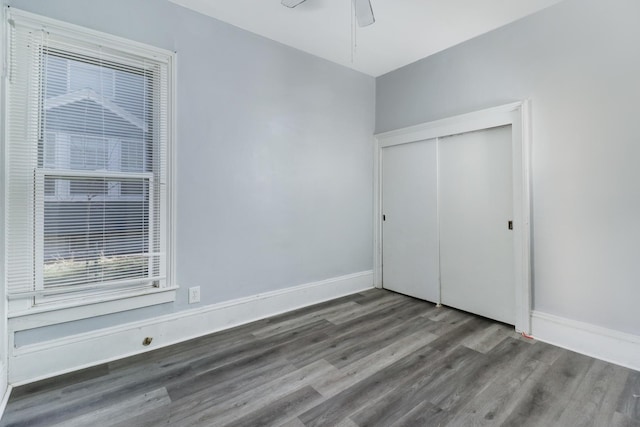 unfurnished bedroom featuring wood-type flooring, a closet, and ceiling fan