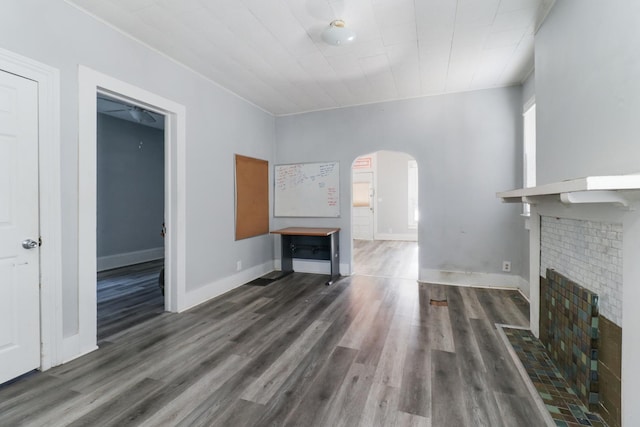 unfurnished living room with a fireplace, plenty of natural light, and dark wood-type flooring