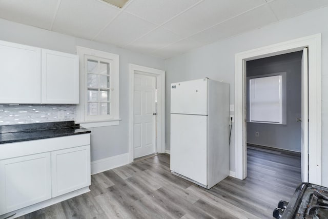 kitchen featuring white fridge, white cabinetry, backsplash, and light hardwood / wood-style flooring