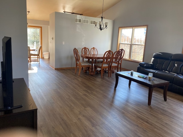 living room featuring wood-type flooring, high vaulted ceiling, and an inviting chandelier