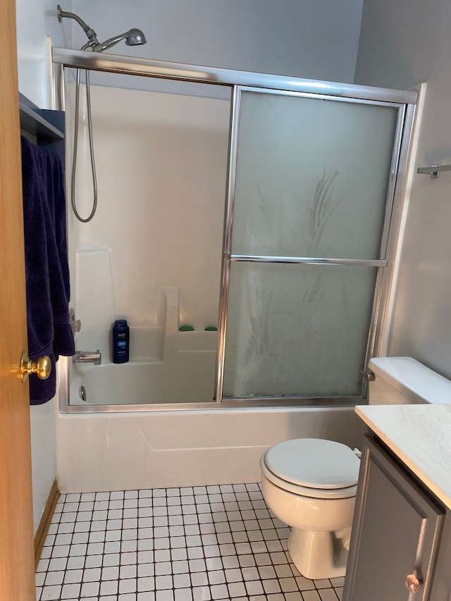 full bathroom with tile patterned flooring, vanity, combined bath / shower with glass door, and toilet