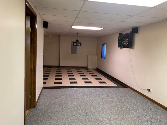 basement featuring carpet, a paneled ceiling, and electric panel