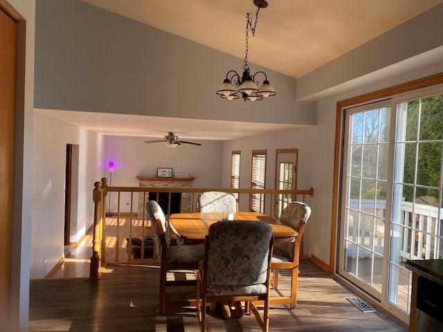 dining room with ceiling fan with notable chandelier, lofted ceiling, and hardwood / wood-style flooring