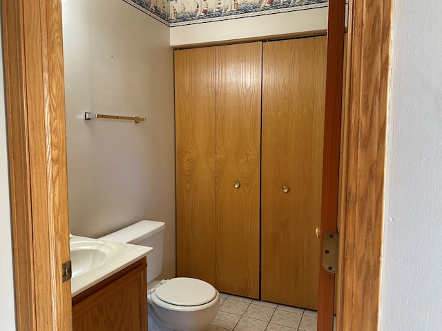 bathroom with toilet, vanity, and tile patterned floors